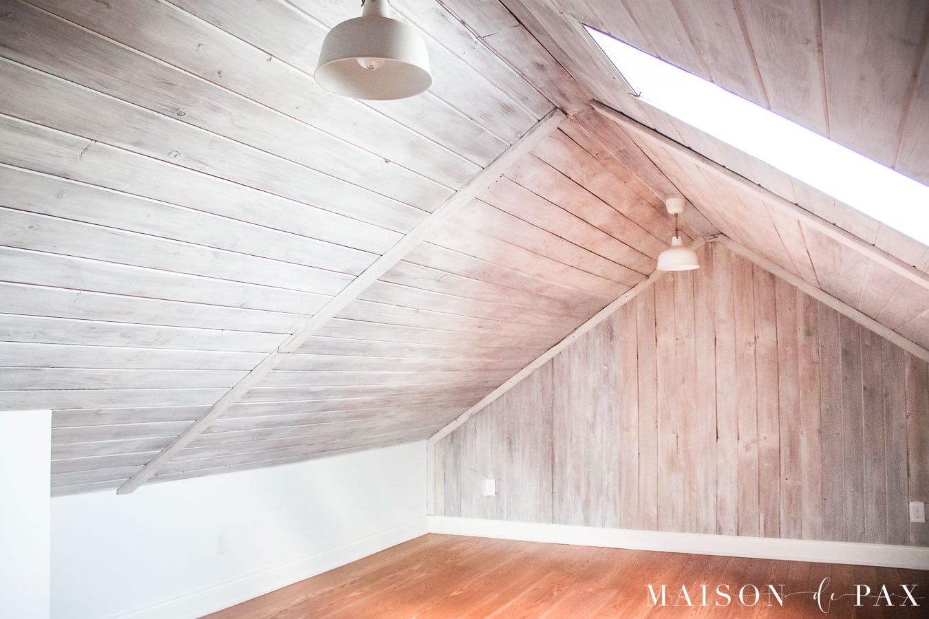 attic remodel with planked ceiling and accent wall