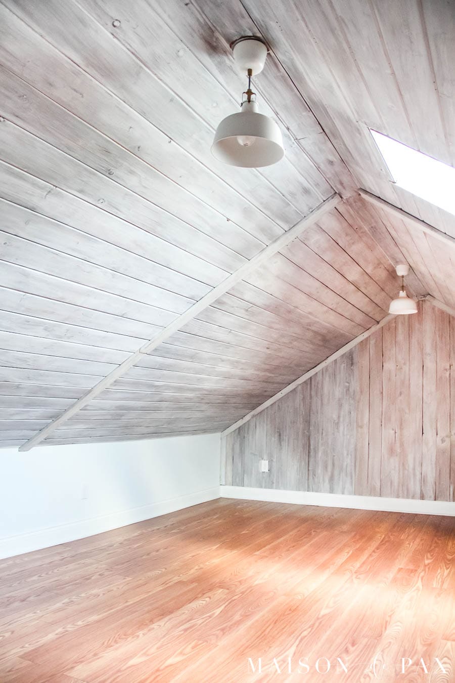 attic remodel with whitewash planks and skylight