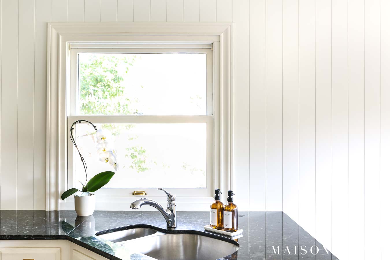 kitchen sink with window surrounded by charming nickel gap vertical plank wall paneling backsplash