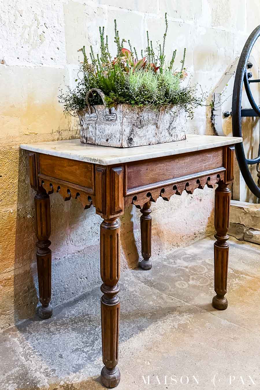intricately carved wooden table with marble top