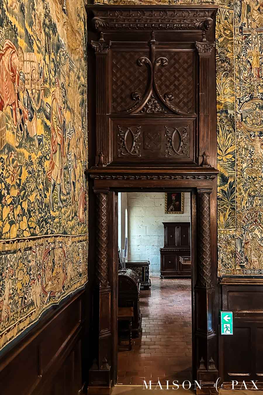 elaborate dark wood carvings over wood door and wood paneling in French chateau