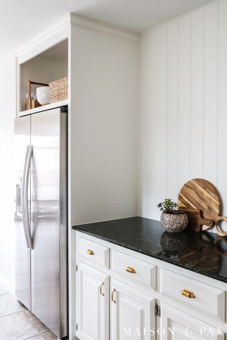 DIY over fridge cabinet surround in white kitchen with vertical nickel gap paneling