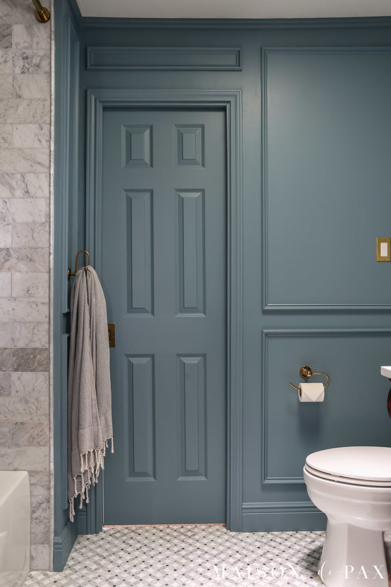 small bathroom painted a moody blue green with DIY picture frame molding and cararra marble tile