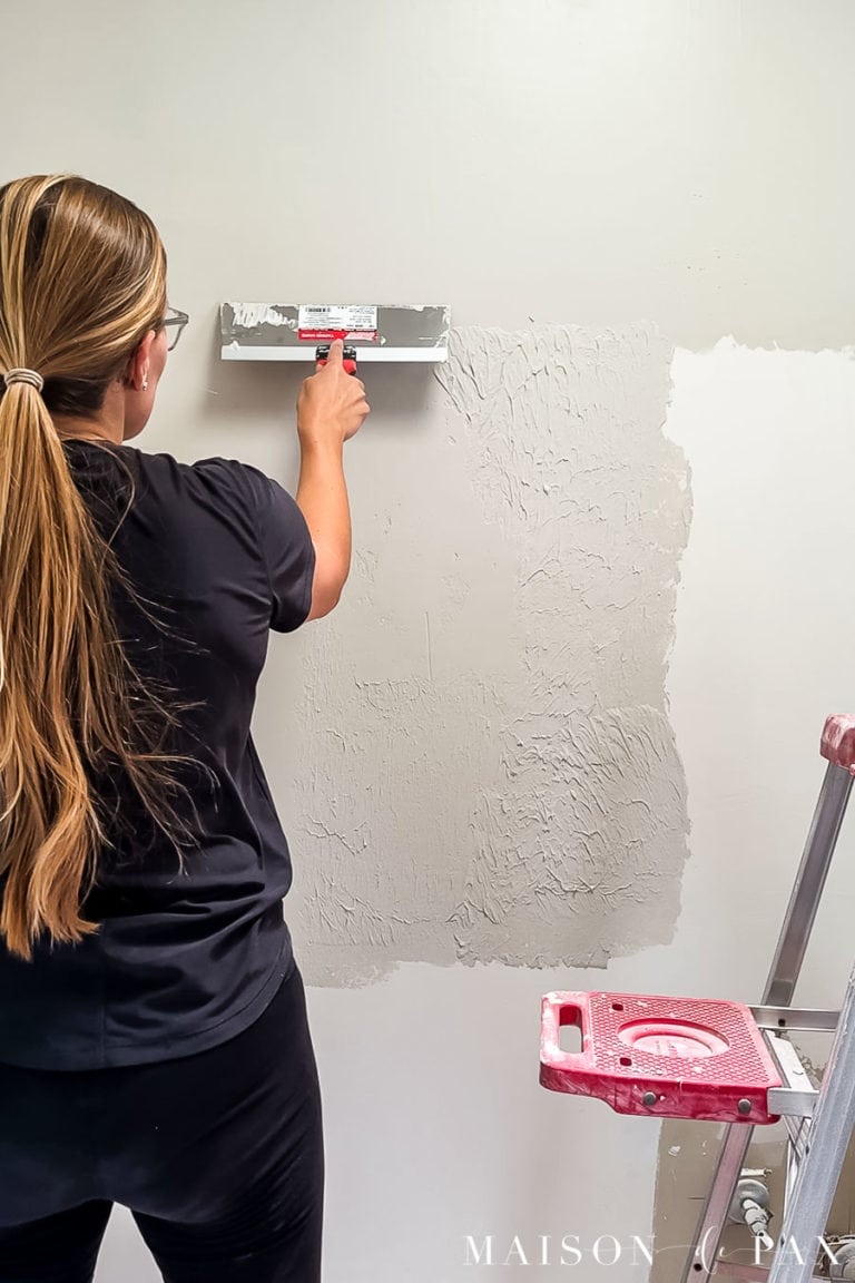 woman skim coating walls for smooth texture