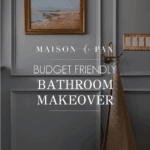 image of gray blue bathroom with picture frame molding and text overlay: budget friendly bathroom makeover