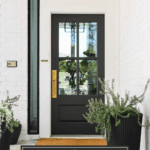 Soft black front door painted Sherwin Williams Iron Ore on white brick house exterior