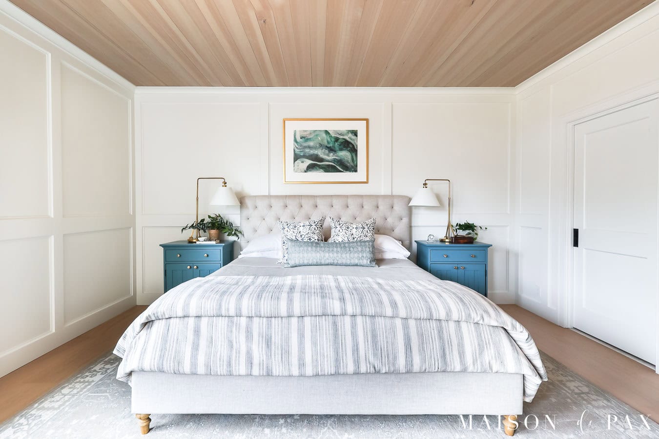 Sherwin Williams Pure White walls and trim in bright bedroom with warm wood ceiling and blue nightstands